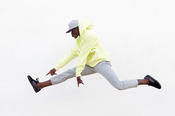 young african man dancer doing leg split in mid air over white background