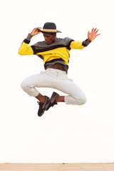 Fototapeta na wymiar stylish young male dancer jumping and showing his moves on white background