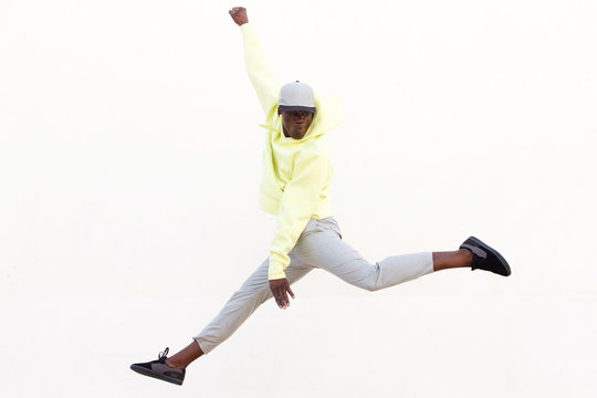 Stylish Young African American Man Jumping And Dancing On White Background