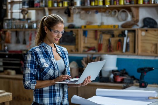 Female carpenter using laptop