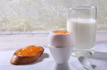 Morning Breakfast set with egg, orange jam on bread toast and milk in glass.