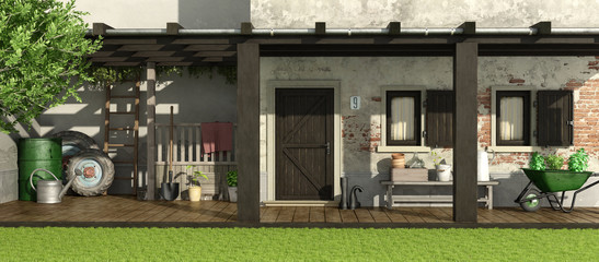 Old house with patio and gardening equipment