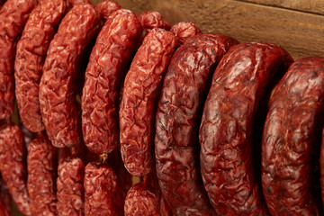 Composition of different type of sausage hanged on wooden background