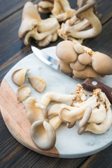 Raw oyster mushrooms slicing on marble cutting board