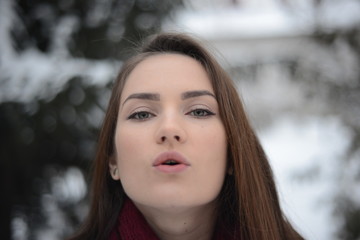 Handsome girl sending virtual kiss in winter park