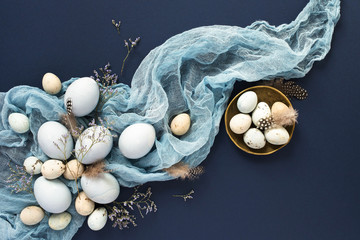 Easter background with blue painted eggs and napkin on dark blue backround.