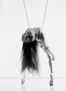 Perfect slim girl with a rope posing on a light background. Sexy athletic body. black and white
