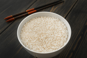 Raw Basmati rice paddy in white porcelain bowl
