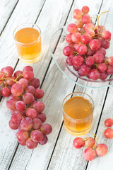 Two glasses of fresh grape juice and red grapes