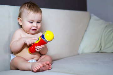Adorable child with colorful toy. Adorable little kid sitting and playing with colorful toy on couch.