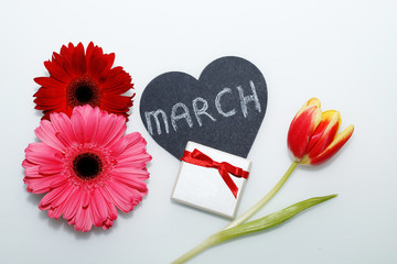 Obraz na płótnie Canvas Postcard on March 8 - International Women's Day. Flowers, decorative heart and gift.