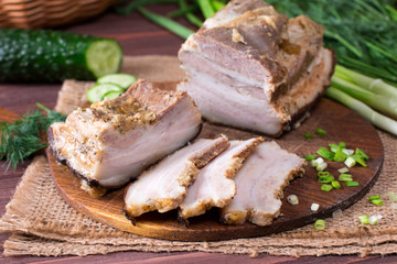 Ukrainian traditional food - salo. Sliced bacon with onion on wooden background