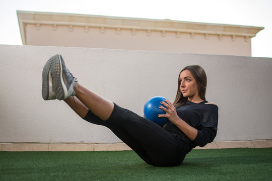 Young Woman Exercising With Medicine Ball Outdoors.