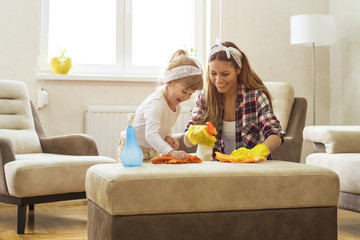 Little girl and  mother cleaning home together and having fun.