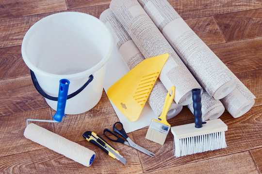 Various tools for home repair and rolls of wallpaper