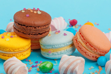 Macarons and sweets on a colored background. Festive mood