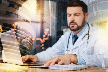 Checking notes. Calm clever concentrated doctor thoughtfully looking at the notes in his notebook...