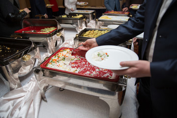 man in suits choosing food at a banquet