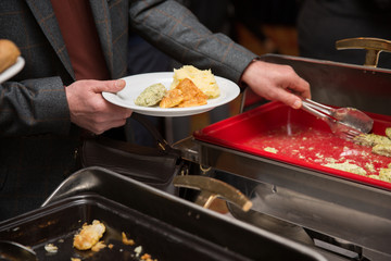 Businessman hands taking food in buffet line indoor in canteen