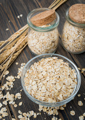 A glass plate of dry oat flakes or oat grains with oat spikes or