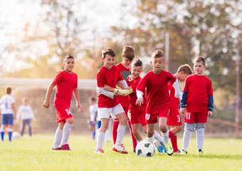 Gordijnen Young children players football match on soccer field © Dusan Kostic