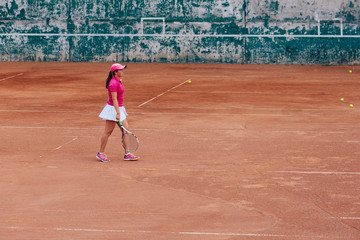 Obraz premium Tennis player. Athlete woman in white skirt and pink t-shirt playing tennis on the court. Sport concept.