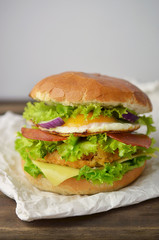 Burger with vegetables, fried egg and salami