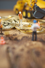 miniature figure people working on Cryptocurrency golden bitcoin