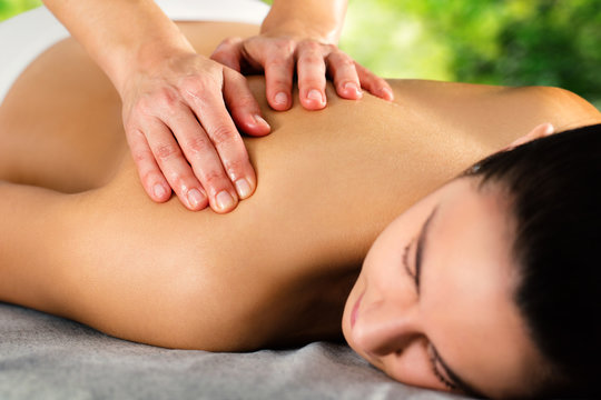 Detail of hands massaging female shoulder.