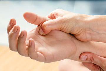 Therapist manipulating hand of female patient.