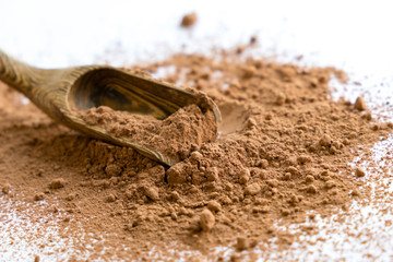 pile cocoa powder in a scoop isolated on white. heap of fresh of chocolate studio shot