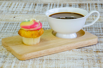 vanilla cupcake and coffee on wooden background