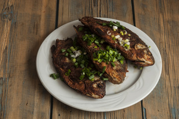 Fried fish crucian in plate on wooden table