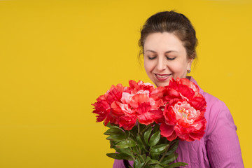 Portrait of the beautiful adult woman of the brunette  with  bouquet of red peony