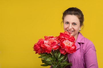 Portrait of the beautiful adult woman of the brunette  with  bouquet of red peony