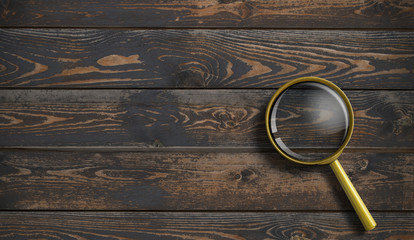 Magnifying glass on wooden desk or table background top view 3d illustration