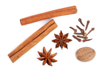 Cinnamon sticks with star anise, nutmeg and clove isolated on white background. Top view