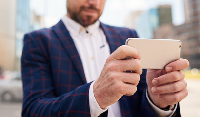 Cropped image of hands of businessman using his smartphone