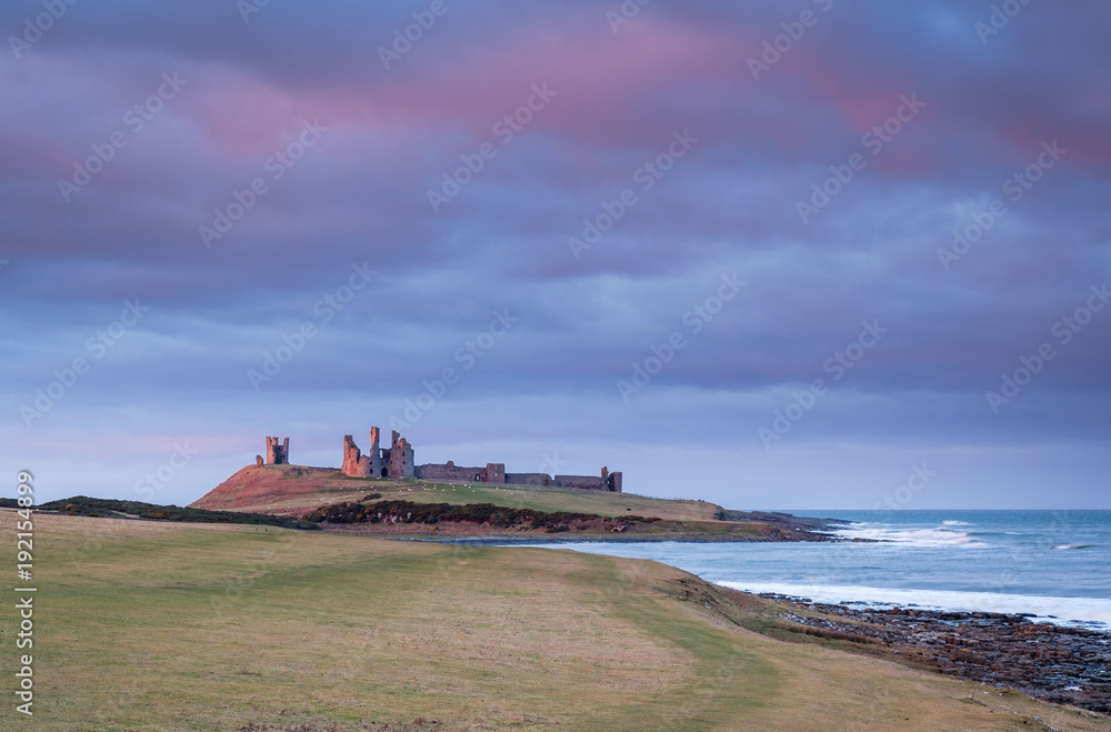 Sticker late sunlight on dunstanburgh castle / located just north of craster, a small fishing village on the