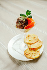 chocolate dessert with a greyfruit cookies and mint in a refined serve, cozy light table setting, restaurant serve