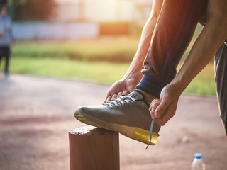 Young asian man tying jogging shoes, Healthy lifestyle concept.