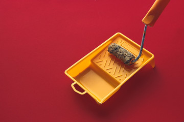 Home Repair Creativity Concept. Roller For Paint And Painting Capacy On Red  Background Surface