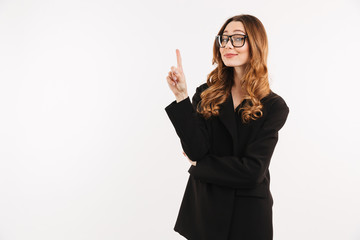 Obraz premium Photo of smart sexual woman in black jacket and eyeglasses smiling and pointing index finger up on copyspace, isolated over white background