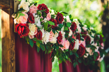 Beautiful floral decoration of a wedding arch of Marsala colors.