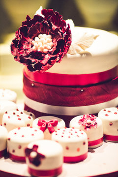 A beautiful cake and capkake decorated with beads, flowers, bows and satin ribbon in Marsal colors.
