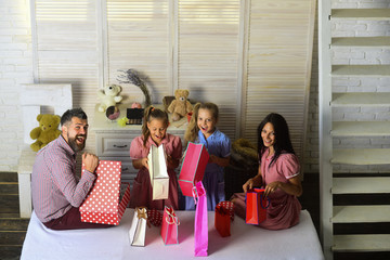 Family with cheerful faces open presents at home