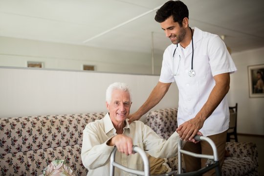 Nurse helping senior man to stand up