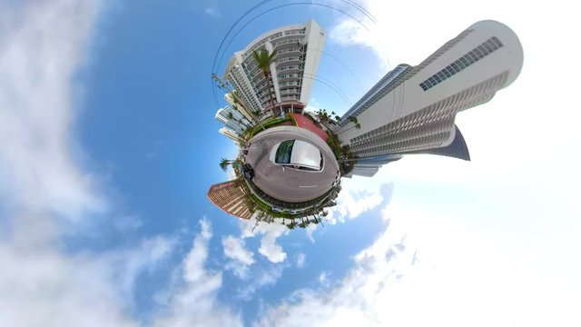 Car driving in a miniaturee tiny city planet with tall buildings