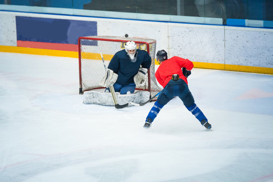 Professional ice hockey player on the ice hockey stadium train together with goalie. Sport photo, edit space, winter game Pyeongchang.