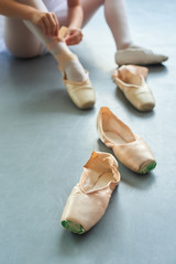Pair of ballet pointe shoes. Female slippers for ballet dance, blurred background. School of classical ballet.